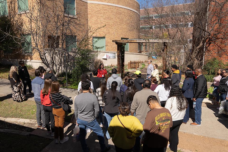 Aerial shot of campus tour guide speaking to crowd of students and parents